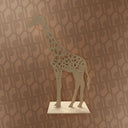 Decorative giraffe sculpture on a pedestal against a patterned wall.