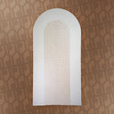 White arch-shaped mirror on a patterned brown background