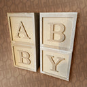 Wooden blocks with letters 'A', 'B', and 'Y' on a patterned background