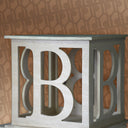 Decorative table with letter 'B' design against a patterned background