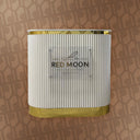 White and gold cylindrical product with 'Red Moon' branding on a patterned background