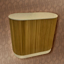 Brown ribbed cylindrical object against a patterned wall