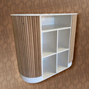 White shelving unit with wooden side against a patterned wall