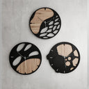 Three modern wall clocks with black and wooden design on a gray surface