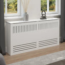 White radiator cover with decorative items on a windowsill in a room.