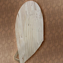 Wooden ironing board against a patterned wall